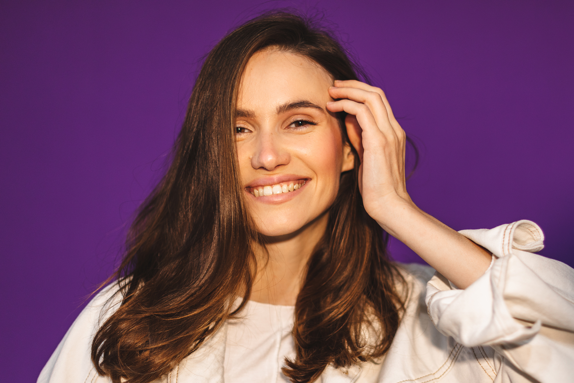 Woman standing in front of purple wall smiling