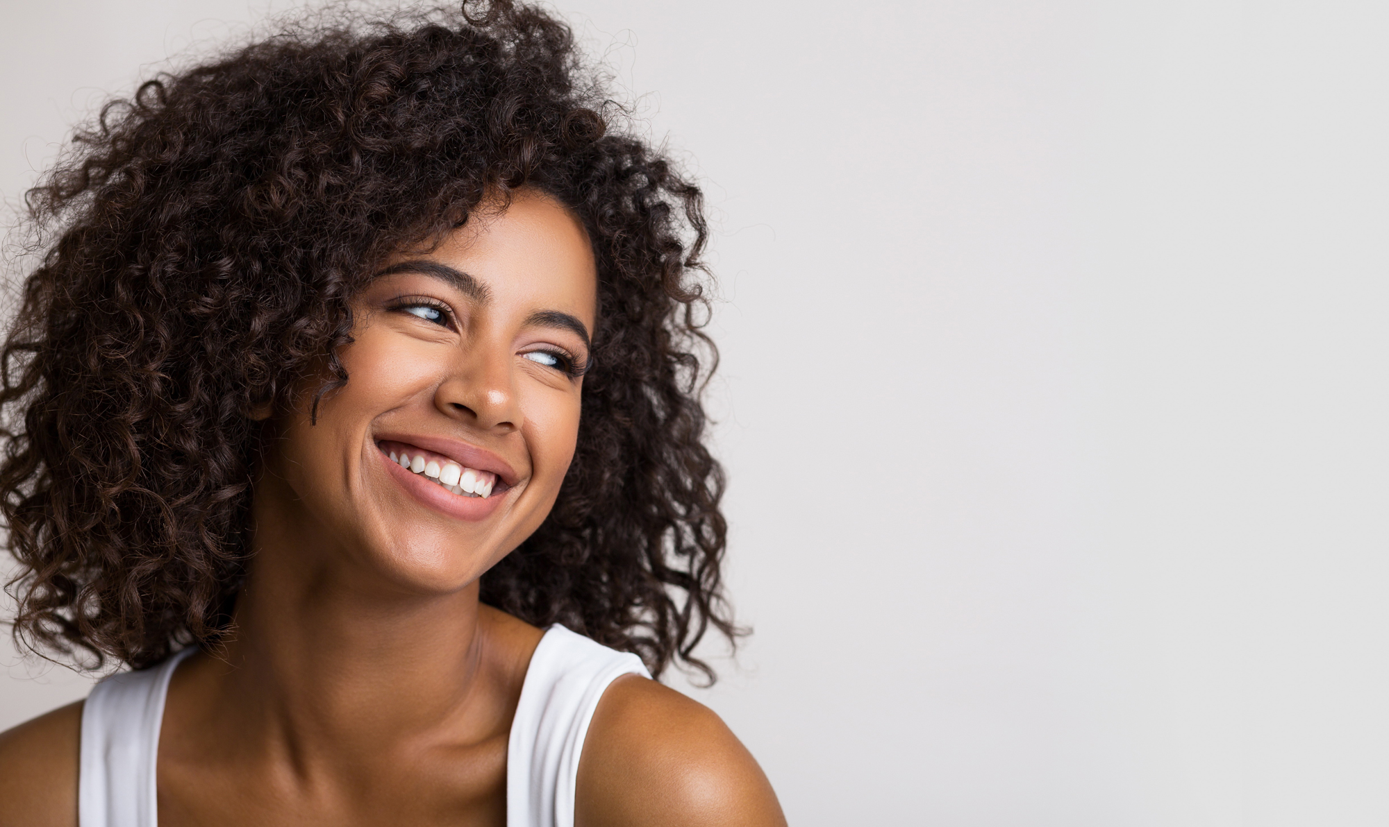 Woman in white tank top smiling